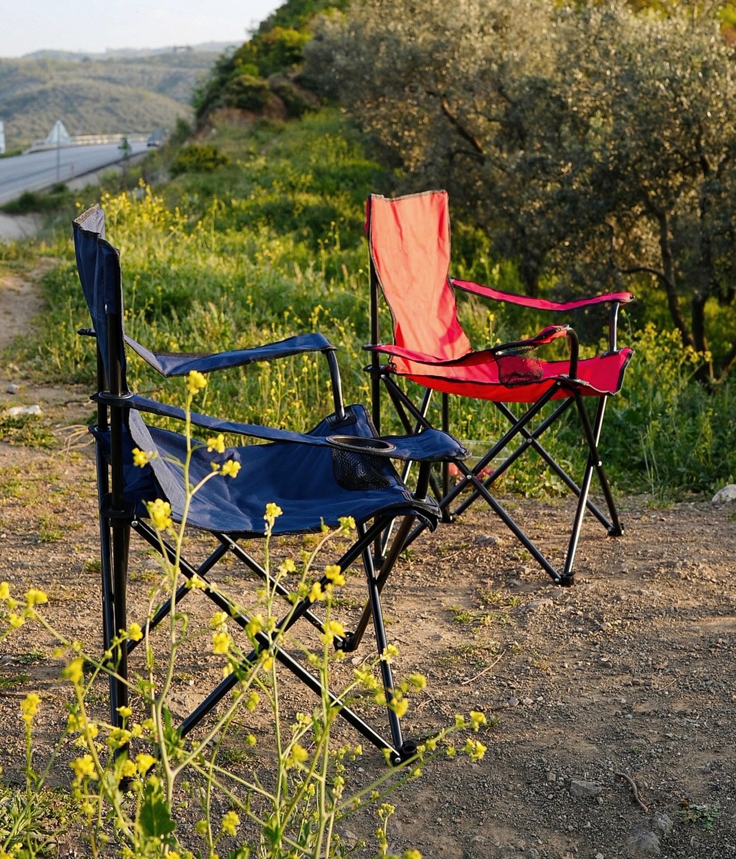Two portable camping chairs on an outdoor trail